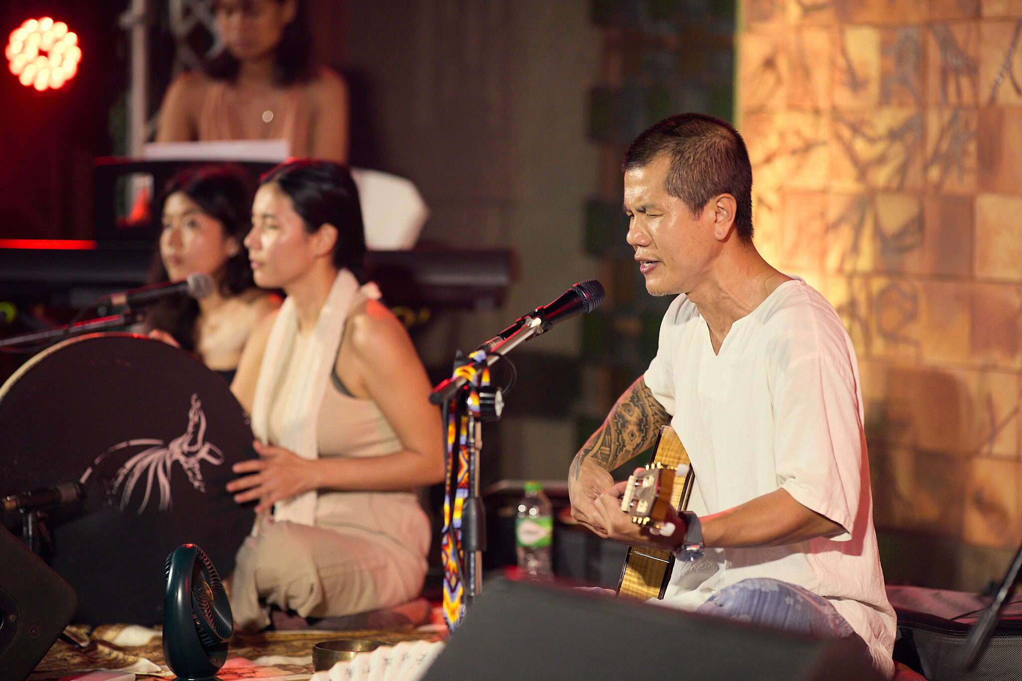 Kay singing and playing guitar with the ensemble